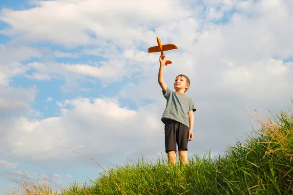 Little boy launches a toy plane into the air. Child launches a toy plane.