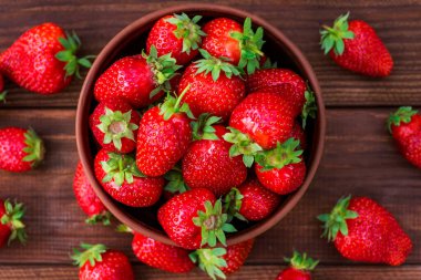 Tahta masadaki kasede taze çilekler. Bir kasede çilek. Üst görünüm.