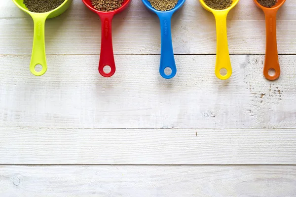 Colorful measuring spoons with spices for kitchen on a white woo