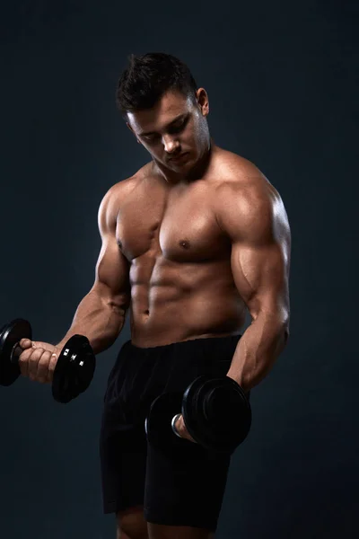 Muskulöser Bodybuilder macht Übungen mit Kurzhantel über schwarzem Ba — Stockfoto