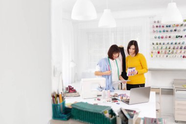 Dikiş atölyesinde çalışan iki genç bayan terzi..