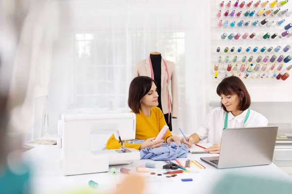 Dos jóvenes costureras trabajando en un estudio de costura . — Foto de Stock