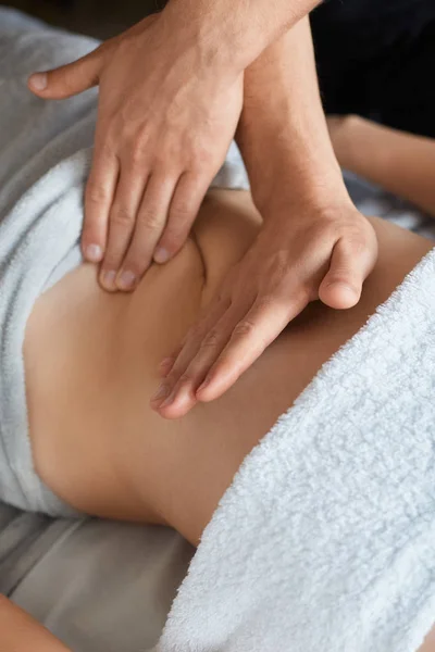 Mulher bonita nova que aprecia a massagem da barriga do anticellulite no spa.Professional massagista está tratando um paciente fêmea no apartment.Relaxamento, beleza, conceito do tratamento do corpo.Massagem caseira — Fotografia de Stock