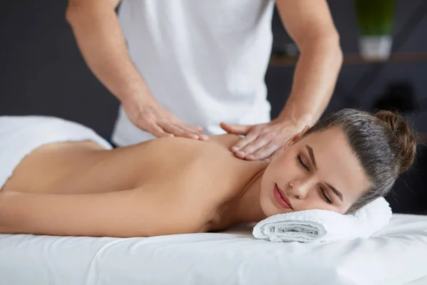 Jovem mulher bonita desfrutando de volta e shouders massagem em spa.Professional massagem terapeuta está tratando uma paciente do sexo feminino no apartamento.Relaxamento, beleza, corpo e rosto tratamento concept.Home massagem — Fotografia de Stock