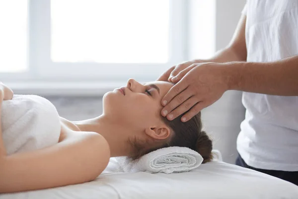 Młoda piękna kobieta twarzy masaże Anti-Aging. Dokonywanie masaż głowy do klient kobiece kobieta mężczyzna terapeuta. Profesjonalnego masażysty. Koncepcja leczenia relaks, uroda, spa, ciała i twarzy — Zdjęcie stockowe