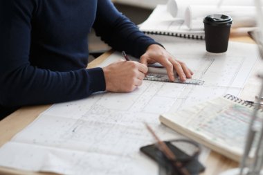 Ofiste planlarla çalışan bir mimar. Mühendis mimari planı inceliyor, bir inşaat projesi çiziyor. İş yerinde oturan sakallı yakışıklı bir adamın portresi. İş inşa kavramı