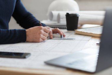 Ofiste planlarla çalışan bir mimar. Mühendis mimari planı inceliyor, bir inşaat projesi çiziyor. İş yerinde oturan sakallı yakışıklı bir adamın portresi. İş inşa kavramı