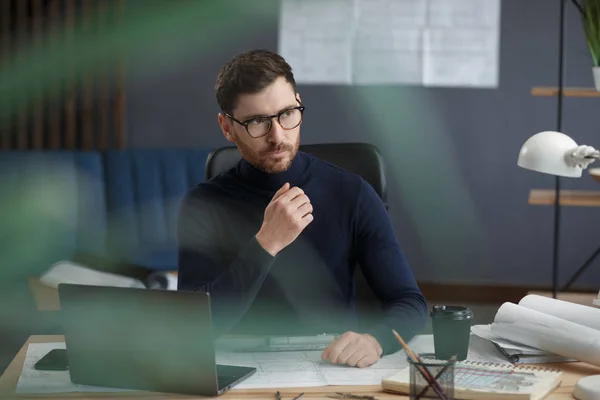 Arquitecto trabajando en oficina con laptop. Retrato de negocios de un hombre barbudo guapo con anteojos sentados en el trabajo. Un hombre de negocios seguro tuvo éxito. Concepto empresarial — Foto de Stock