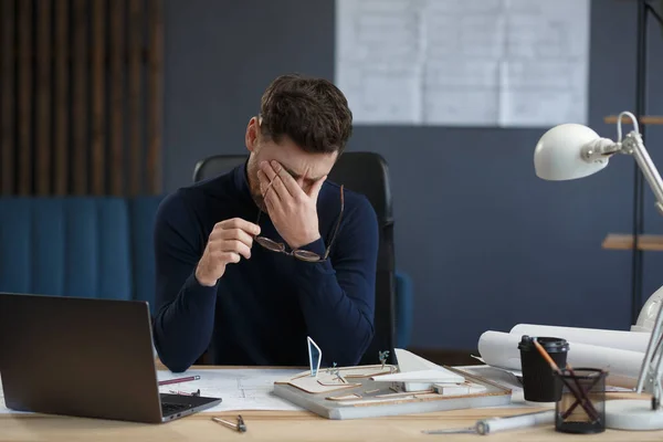 Arquiteto cansado trabalhando horas extras no escritório. Empresário estressado tem problemas financeiros e busca de ideias para superar a crise financeira. Empreendedor em falência. Conceito de esgotamento e excesso de trabalho — Fotografia de Stock