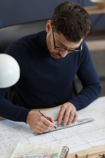 Arquitecto trabajando en la oficina con planos. Ingeniero inspeccionar plan arquitectónico, bosquejando un proyecto de construcción. Retrato de hombre barbudo guapo sentado en el lugar de trabajo. Concepto de construcción empresarial — Foto de Stock