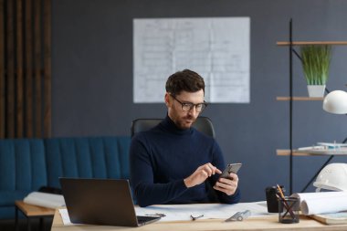 Genç adam akıllı telefon kullanıyor ve gülümsüyor. Mutlu iş adamı cep telefonu uygulamaları kullanıyor, mesaj atıyor, internette geziniyor, akıllı telefona bakıyor. Mobil aygıtlarla çalışan gençlerin kavramı