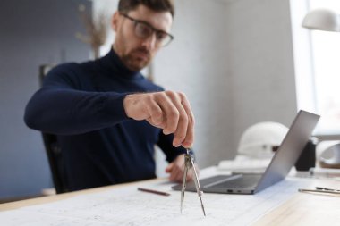 Ofiste planlarla çalışan bir mimar. Mühendis mimari planı inceliyor, bir inşaat projesi çiziyor. İş yerinde oturan sakallı yakışıklı bir adamın portresi. İş inşa kavramı