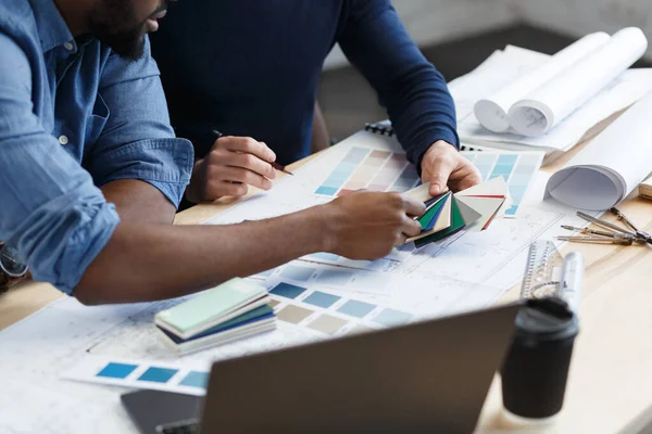 Equipo de ingenieros multirraciales trabajando en la oficina con paleta de colores. Los arquitectos seleccionan colores para la construcción utilizando muestras de color, bocetos y proyectos de construcción de planificación. Socios discutiendo en el trabajo — Foto de Stock