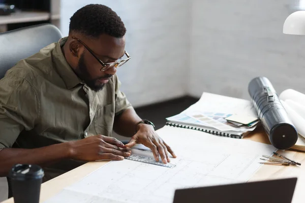 Architecte afro-américain travaillant au bureau avec des plans. Ingénieur inspecter le plan architectural, esquisser un projet de construction. Portrait d'un bel homme noir assis sur le lieu de travail. Concept d'entreprise — Photo