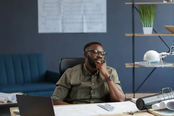 Architecte afro-américain travaillant au bureau avec ordinateur portable.Portrait d'affaires d'un bel homme barbu noir portant des lunettes assis sur le lieu de travail.Homme d'affaires confiant est devenu couronné de succès.Concept d'entreprise — Photo