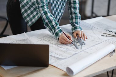 Mimar ofiste planlar çiziyor. Mühendis bir inşaat projesi çiziyor. Mimari plan. İşine odaklanmış güzel bir kadının yakın plan portresi. İş inşa kavramı