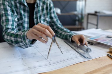 Mimar ofiste planlar çiziyor. Mühendis bir inşaat projesi çiziyor. Mimari plan. İşine odaklanmış güzel bir kadının yakın plan portresi. İş inşa kavramı