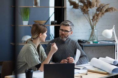 Mühendis ekibi planlar ve mimari ekipmanlarla çalışıyor, taslak çiziyor, müzakere ediyor ve inşaat projesini planlıyor. Ortaklar iş yerinde tartışıyor. İş inşa kavramı