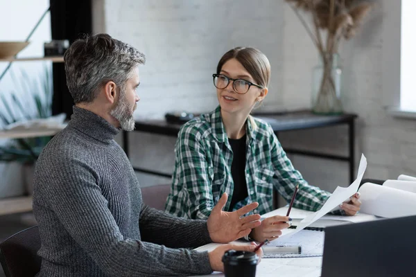 Equipo de diseñadores de interiores que trabaja en la oficina con planos y equipos de arquitectos, bocetos, negociación y planificación de proyectos de construcción. Socios discutiendo en el trabajo. Concepto de construcción empresarial — Foto de Stock