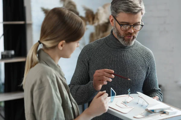 3D-arkitektteam som arbetar i kontor med byggnad 3D-modell. Arkitekter inspekterar byggnadslayout, planerar byggprojekt, söker nya idéer. Partners diskuterar på jobbet. Affärsidé — Stockfoto