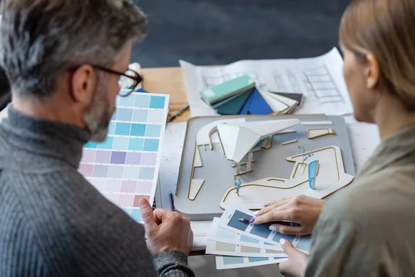 Equipo de interioristas trabajando en oficina con paleta de colores. Los arquitectos seleccionan colores para la construcción utilizando muestras de color, bocetos y proyectos de construcción de planificación. Socios discutiendo en el trabajo — Foto de Stock