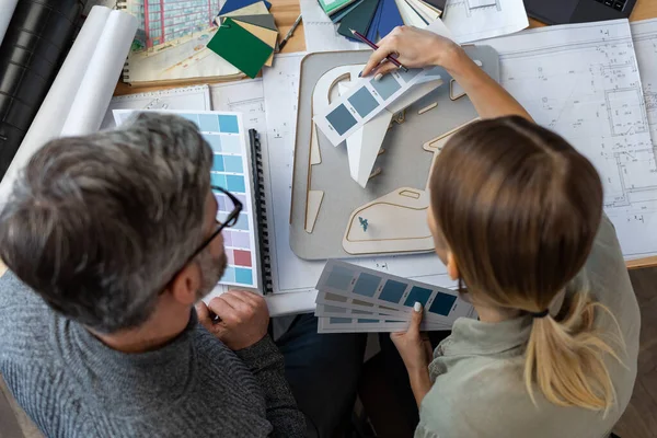 Equipo de interioristas trabajando en oficina con paleta de colores. Los arquitectos seleccionan colores para la construcción utilizando muestras de color, bocetos y proyectos de construcción de planificación. Socios discutiendo en el trabajo — Foto de Stock