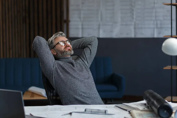 Diseñador toma un descanso del trabajo en la oficina.Arquitecto reflexiona sobre el plan arquitectónico, la búsqueda de nuevas ideas para el proyecto de construcción.Retrato de hombre barbudo guapo sentado en el lugar de trabajo.Concepto de negocio — Foto de Stock