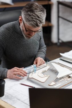 3D mimar, 3D model bir binada çalışıyor. Mühendis bina planını inceliyor, inşaat projesi için yeni fikirler arıyor. İş yerindeki yakışıklı sakallı adam. İş inşa kavramı
