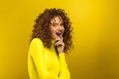 Wow. Reaction on unexpected news. Beautiful women with wide open eyes covering open mouth with hand, being surprised and shocked. Copy space,yellow background. Expressive faces. Body language concept