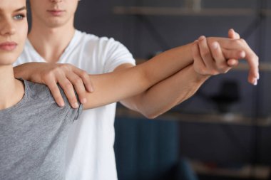 Bayan hasta fizyoterapist ile fiziksel egzersizleri yapıyor. Erkek terapist tedavi omuz genç sporcunun yaralandı. Travma sonrası rehabilitasyon, spor fizik tedavi, kurtarma kavramı