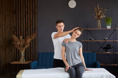 Bayan hasta fizyoterapist ile fiziksel egzersizleri yapıyor. Erkek terapist tedavi boyun genç sporcunun yaralandı. Travma sonrası rehabilitasyon, spor fizik tedavi, kurtarma kavramı