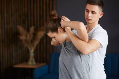 Bayan hasta fizyoterapist ile fiziksel egzersizleri yapıyor. Erkek terapist tedavi boyun genç sporcunun yaralandı. Travma sonrası rehabilitasyon, spor fizik tedavi, kurtarma kavramı