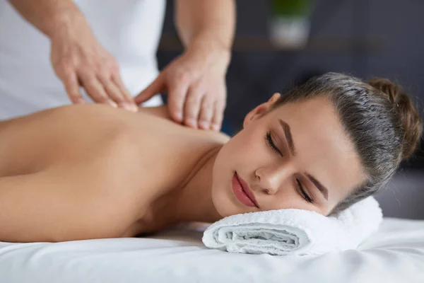 Junge schöne Frau genießt Rücken- und Shouders Massage in spa.professional Masseur behandelt eine Patientin in Wohnung.Entspannung, Schönheit, Körper-und Gesichtsbehandlung Konzept.Home Massage — Stockfoto