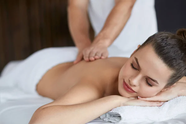 Ung vacker kvinna njuter av rygg och shouders massage i spa.Professionell massage terapeut behandlar en kvinnlig patient i lägenhet.Avkoppling, skönhet, kropp och ansikte behandlingskoncept.Hem massage — Stockfoto
