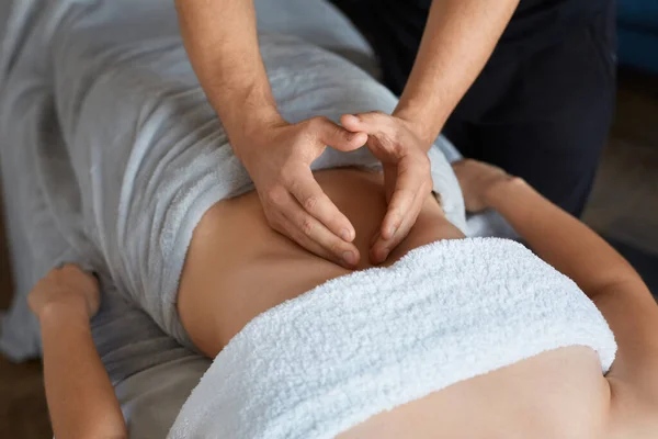 Ung vacker kvinna njuter av anticellulite magen massage i spa.Professionell massage terapeut behandlar en kvinnlig patient i lägenhet.Avkoppling, skönhet, kroppsbehandling koncept.Hem massage — Stockfoto