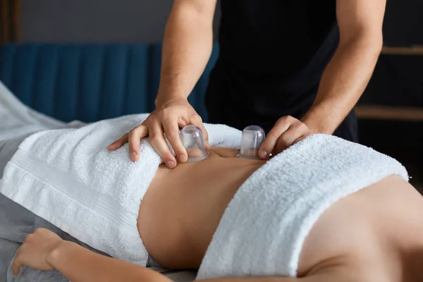 Młoda piękna kobieta korzystających z masażu filiżanek w spa.Professional masażystka leczy pacjentkę w apartamencie.Relaks, piękno, ciało i twarzy leczenie koncept.Home masaż — Zdjęcie stockowe
