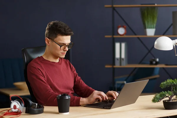Ev ofisinde dizüstü bilgisayarla çalışan genç bir serbest çalışan. İş dünyası