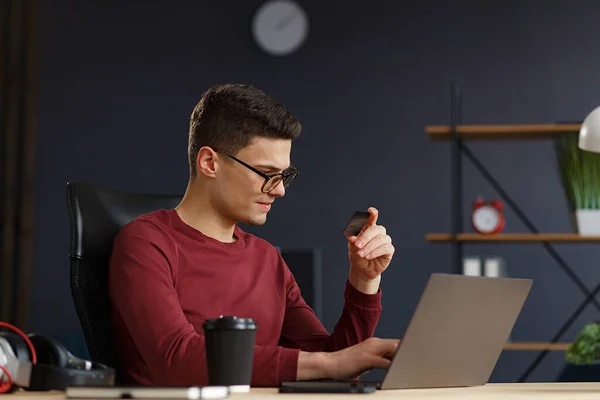 Jonge freelancer in het thuiskantoor met kredietkaart en het gebruik van la — Stockfoto