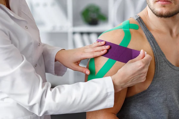 Kineziyoloji bandı. Fizyoterapist kineziyoloji bandı uyguluyor.