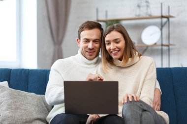 Evde kal. İnternetteki bir toplantı için dizüstü bilgisayar kullanan gülümseyen aile portresi, video görüşmesi, ebeveynlerle, çocuklarla, akrabalarla video konferansı. Kendini soyutlama. Karantina döneminde evde vakit geçirmek