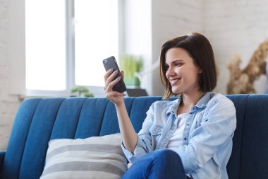 Evde kal. Kendini soyutlama. Sosyal medya zamanı. Karantina döneminde evde vakit geçirmek. Rahatlama, rahatlama ve stres yönetimi. Mobil aygıtlarla çalışan gençlerin kavramı