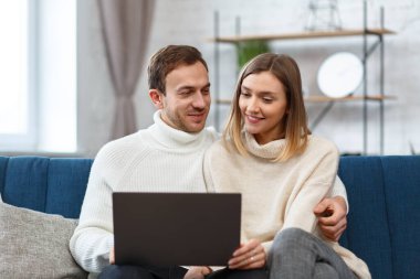 Evde kal. İnternetteki bir toplantı için dizüstü bilgisayar kullanan gülümseyen aile portresi, video görüşmesi, ebeveynlerle, çocuklarla, akrabalarla video konferansı. Kendini soyutlama. Karantina döneminde evde vakit geçirmek
