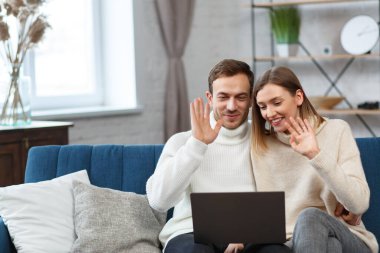 Evde kal. İnternetteki bir toplantı için dizüstü bilgisayar kullanan gülümseyen aile portresi, video görüşmesi, ebeveynlerle, çocuklarla, akrabalarla video konferansı. Kendini soyutlama. Karantina döneminde evde vakit geçirmek