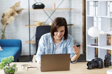 Evde kredi kartı tutan ve dizüstü bilgisayar kullanan genç bir serbest çalışan. İnternetten alışveriş, online ödemeler. İnternetten bilet ayırtıyorum. Modern teknoloji kavramı