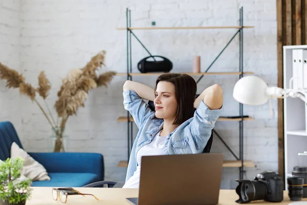 Jobbar hemifrån. Porträtt av leende kvinnlig frilansare med laptop. Avslappning efter att ha fått goda resultat i arbetet. Begreppet ungdomar som arbetar med mobila enheter — Stockfoto