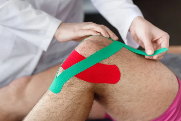 Kinesiology taping.Physical therapist applying kinesiology tape