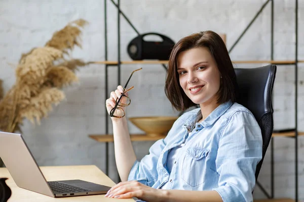 Jobbar hemifrån. Kommunikation online. Porträtt av leende kvinnlig frilansare med bärbar dator — Stockfoto