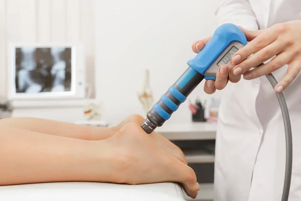 Extracorporeal Shockwave Therapy ESWT cerrahi olmayan tedaviler. Şok dalgalarıyla plantarfascitis için fizyoterapi. Ağrı kesici, normalleştirme ve yenilenme, iyileşme sürecinin canlandırılması.