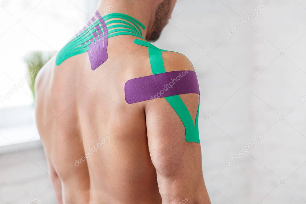 Kinesiology taping. Kinesiology tape on patient neck. Injured trapezius muscles treatment of young male athlete. Post traumatic rehabilitation, sport physical therapy, recovery concept