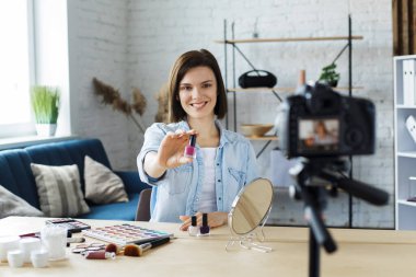 Genç bayan blogcu güzellik blogu için kozmetik hakkında özel bir video kaydediyor. Vlog oje test ediyor ve sosyal ağda canlı yayın yapıyor. Bloglama, video bloglama, makyaj konsepti